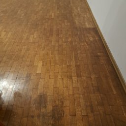 PRO-PODŁOGI - układanie , renowacja - Parkiet dębowy przed renowacją. Widoczne zarysowania i przebarwienia na powierzchni. Ujęcie z góry, perspektywa pod kątem. Tekst 'PRZED' na górze zdjęcia.