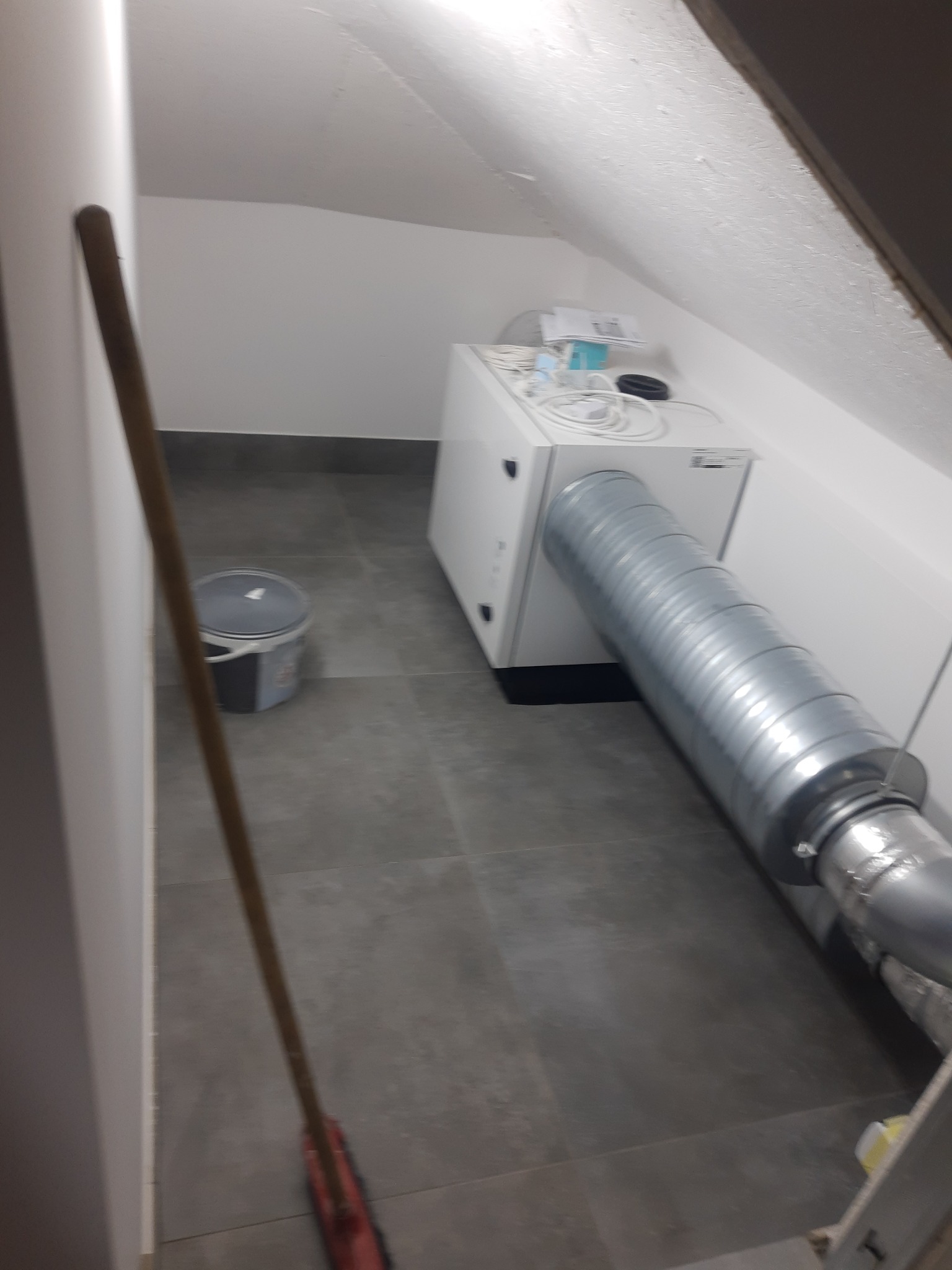 Instalacja wentylacji mechanicznej z rekuperacją w poddaszowym pomieszczeniu, widoczny przewód wentylacyjny. Usługa wykonana w Krakowie.