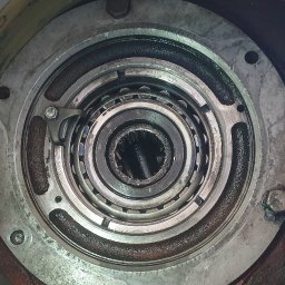 Mateusz Profus - Wnętrze piasty koła z widocznymi łożyskami i elementami mocującymi. Detal mechanizmu z bliska, ukazujący zużycie i smar.