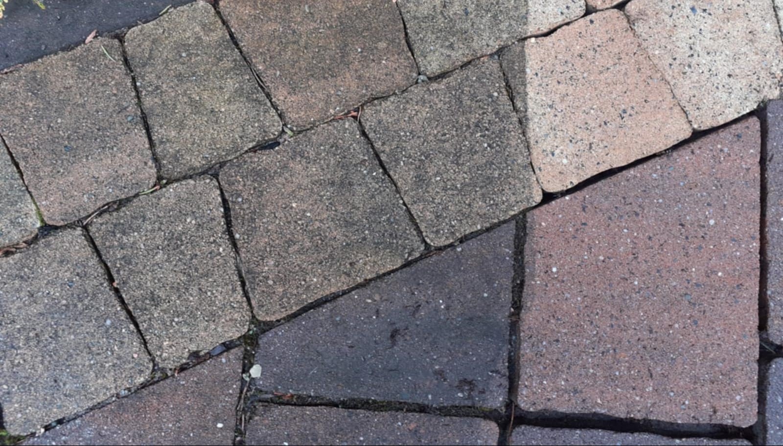 Częściowo wyczyszczona kostka brukowa w Skoczowie. Lewa strona szara, zabrudzona; prawa strona w odcieniach różu, czysta. Widoczna różnica po czyszczeniu.