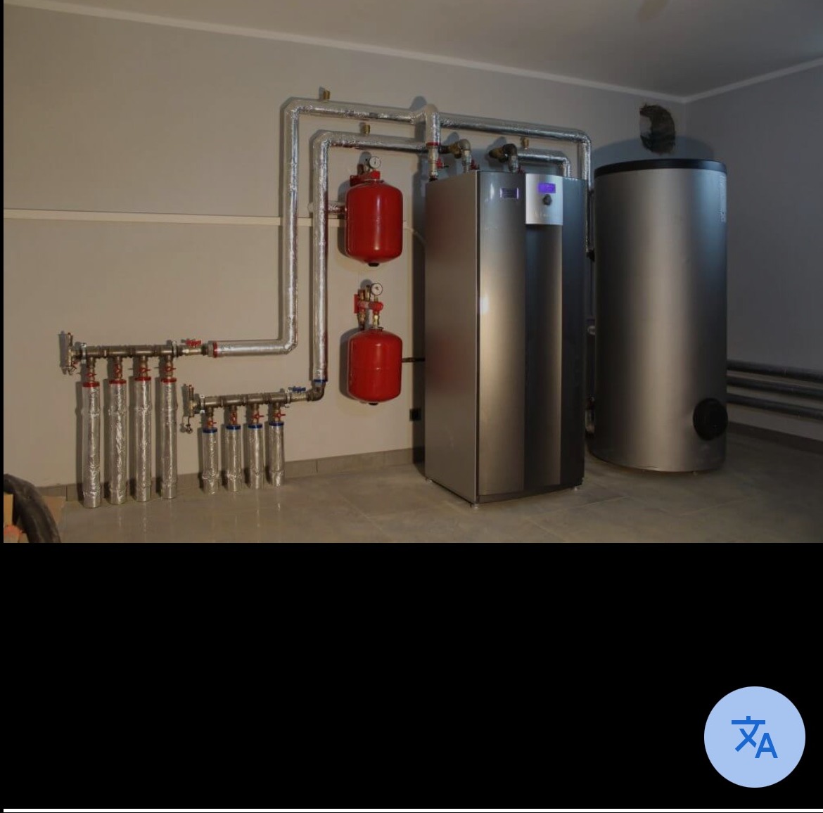 Kompleksowa kotłownia: srebrny piec, zbiornik buforowy i instalacja z czerwonymi zbiornikami wyrównawczymi, rurami w izolacji. Nowoczesne rozwiązanie grzewcze.