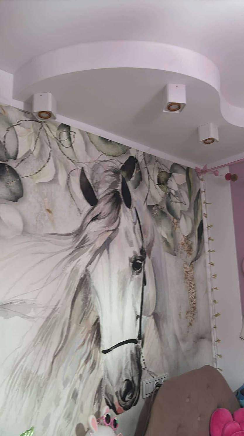 Pokój dziecięcy z fototapetą konia na ścianie, oświetleniem punktowym w podwieszanym suficie. Fragment dziecięcego fotela i dekoracji w kadrze.