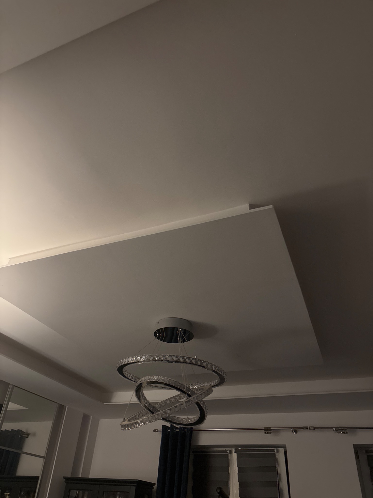 Podwieszany sufit z dekoracyjnym oświetleniem LED w kształcie pierścieni. Widoczne wykończenia i detale wnętrza.