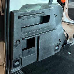 Lucky Detailing Polska OLEKSANDR SHCHUTSKYI - Wnętrze bagażnika samochodu z czarną tapicerką i plastikowymi elementami. Widoczne schowki i mocowania. Detal wnętrza pojazdu po czyszczeniu.