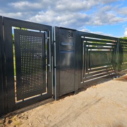 Usługi Spawalnicze Krzysztof Skorniak - Nowoczesna, grafitowa brama wjazdowa z perforowanymi panelami i numerem domu '38 Skwierzyńska', na tle błękitnego nieba z chmurami.