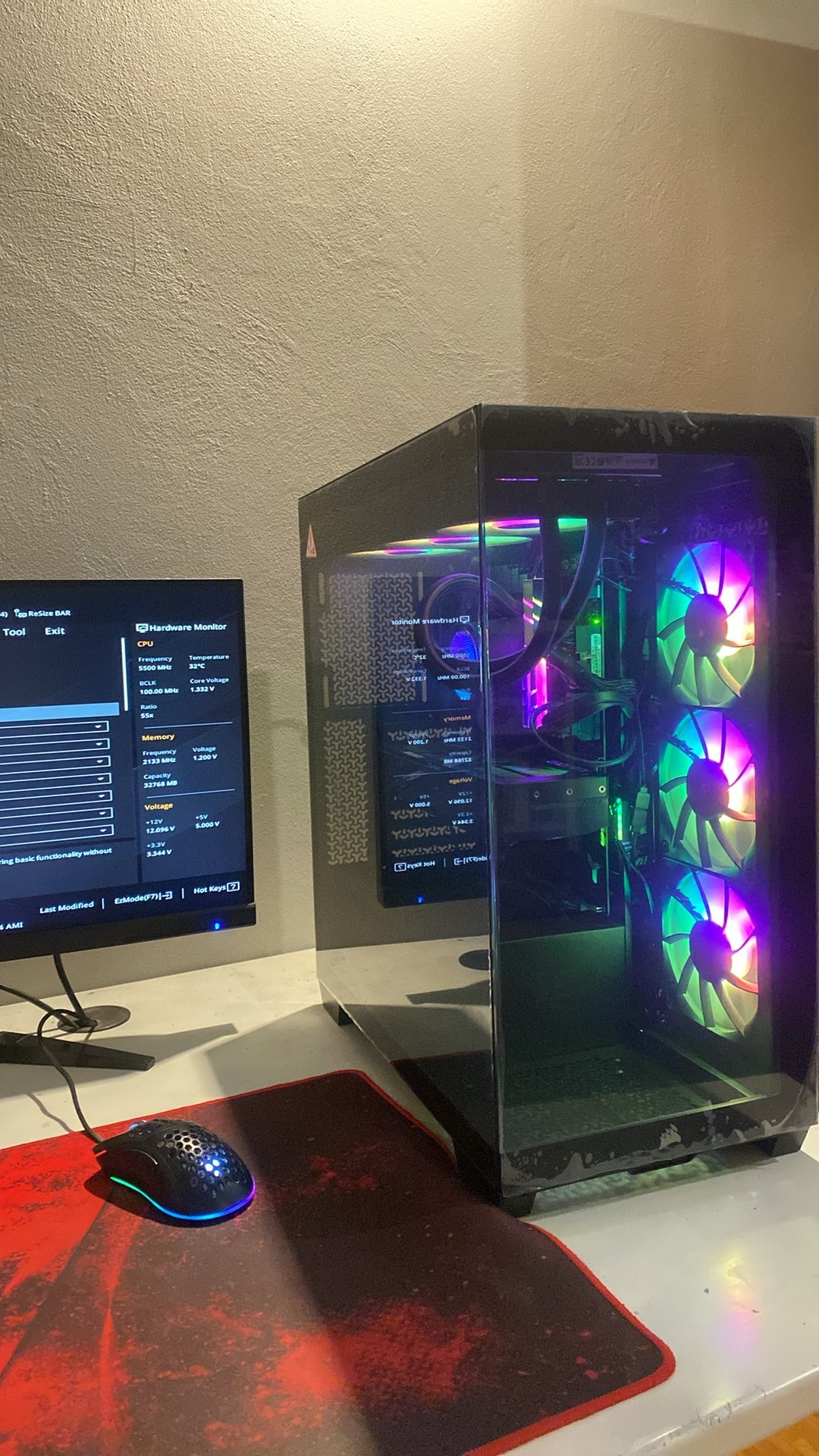 Komputer stacjonarny z podświetleniem RGB, widoczny monitor z parametrami sprzętowymi, mysz na podkładce. Sprzęt gotowy do pracy, konfiguracja po instalacji.