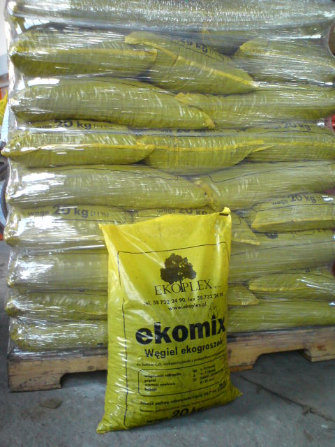 Paleta z workami opału, w pierwszym planie żółty worek z napisem 'ekomix Węgiel ekogroszek' firmy EKOPLEX.