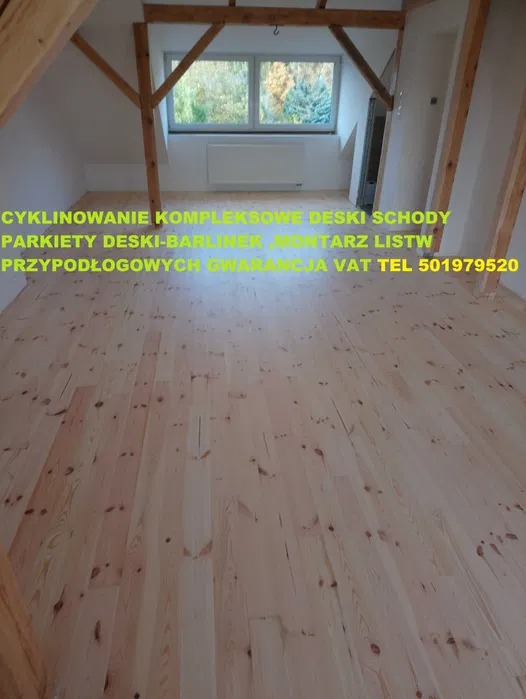 Jasna, drewniana podłoga na poddaszu z oknem. Widoczne belki stropowe. Na zdjęciu widoczny tekst reklamowy.