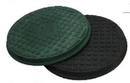 Zielona i czarna, okrągła pokrywa studni z fakturą kratki, ułożone jedna na drugiej, widok z góry, lekko z boku.