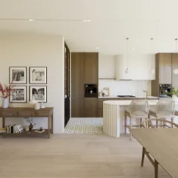 Jasne, przestronne wnętrze z drewnianą zabudową kuchenną, wyspą i dekoracyjnymi lampami. Uwagę przykuwają zdjęcia rodzinne i drewniany stolik z dekoracjami.