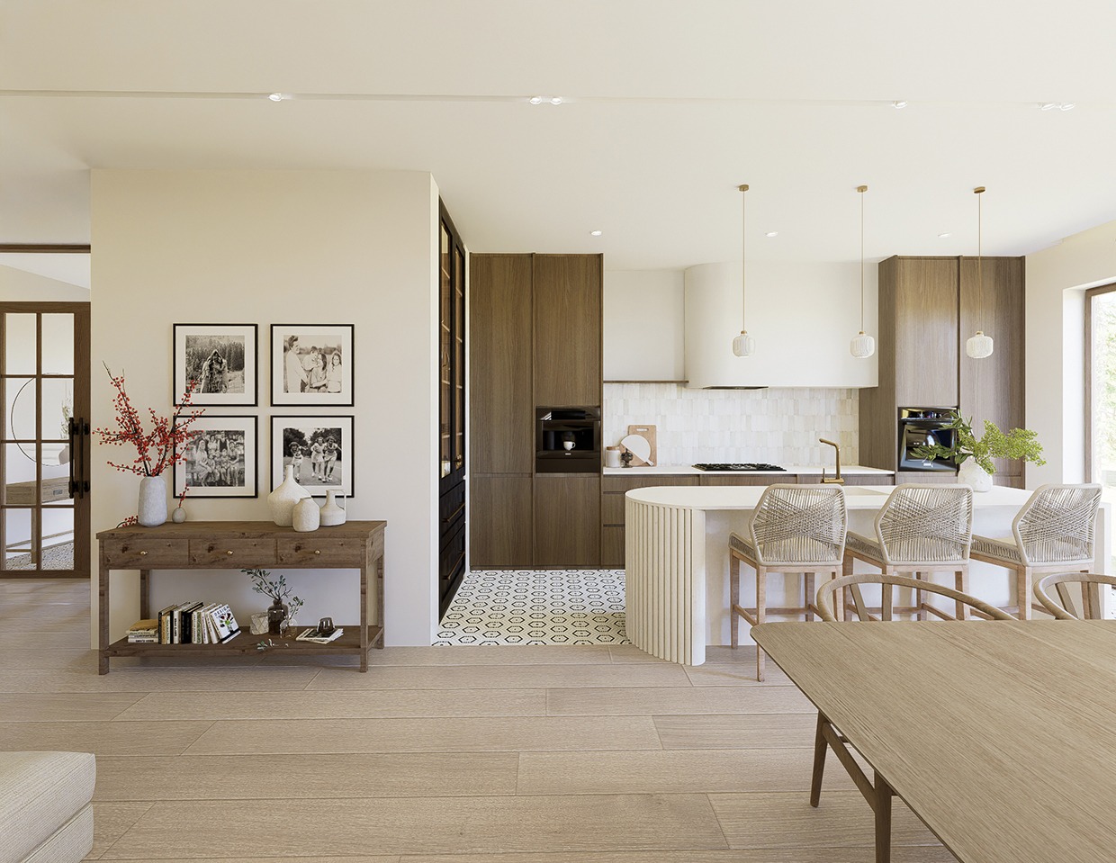 Jasne, przestronne wnętrze z drewnianą zabudową kuchenną, wyspą i dekoracyjnymi lampami. Uwagę przykuwają zdjęcia rodzinne i drewniany stolik z dekoracjami.