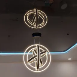 Błyszczący, czarny sufit z podświetleniem LED wzdłuż krawędzi i nowoczesnymi, okrągłymi lampami wiszącymi z białym światłem. Nowoczesne oświetlenie.