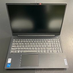 MKS Polska Rusinek Spółka Jawna - Otwarty laptop Lenovo z czarnym ekranem i szarą klawiaturą na ciemnym blacie. Widoczny touchpad, naklejka Intel Core i logo Lenovo. Górny widok.