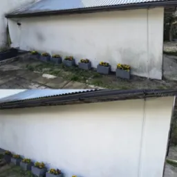 Zdjęcie elewacji budynku przed i po czyszczeniu, z widocznymi różnicami w zabrudzeniach. Rząd donic z kwiatami wzdłuż ściany, blaszany dach.