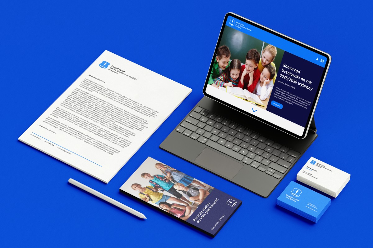 Komplet materiałów identyfikacji wizualnej szkoły na niebieskim tle: list, wizytówki, ulotka i strona www na tablecie. Spójny design, logo szkoły.