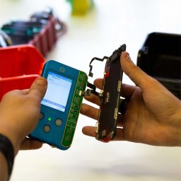 FreshPC - Naprawa telefonów I Serwis komputerów - Serwis iPhone X: Testowanie ekranu dotykowego za pomocą specjalistycznego testera przed montażem. Widoczne złącza i elementy elektroniki.