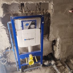 Renovation & Construction Zbigniew Bogdan - Stelaż podtynkowy Geberit Sigma zamontowany w surowej łazience, widoczne rury doprowadzające wodę. Etap prac instalacyjnych przed wykończeniem.