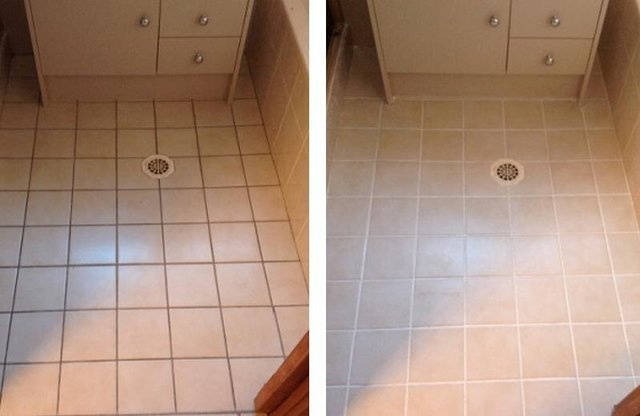 Zdjęcie 'przed i po' czyszczenia jasnych, kwadratowych płytek podłogowych w łazience z odpływem. Po prawej stronie płytki są wyraźnie czystsze i jaśniejsze.