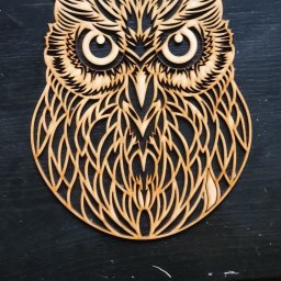 MakeThemKnow Grzegorz Palonek - Drewniana ozdoba w kształcie ażurowej sowy na ciemnym tle. Precyzyjne wycięcie detali, widoczna struktura drewna. Dekoracja wykonana metodą CNC.