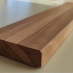 Artorix - Precyzyjnie obrobiona deska z jasnego drewna, ukazująca gładką powierzchnię i zaokrąglone krawędzie. Widoczne naturalne usłojenie drewna. Idealna do wykończenia wnętrz.