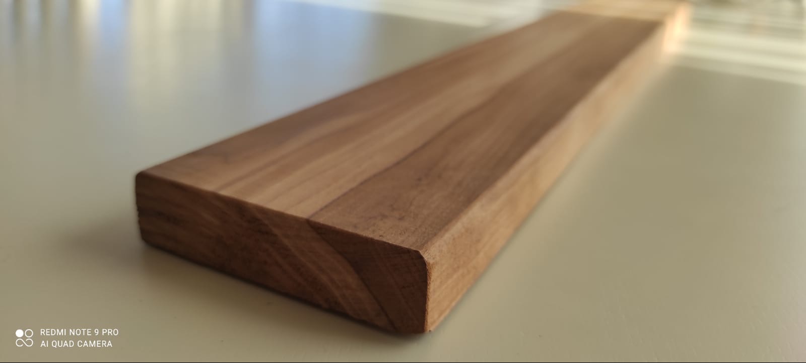 Precyzyjnie obrobiona deska z jasnego drewna, ukazująca gładką powierzchnię i zaokrąglone krawędzie. Widoczne naturalne usłojenie drewna. Idealna do wykończenia wnętrz.
