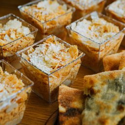 Na zdjęciu znajdują się koreczki z pchali, bakłażan, chaczapuri oraz deser – napoleonka. To zestaw gruzińskich przekąsek i słodkości, idealny na catering i eventy, łączący tradycyjne smaki z elegancką formą podania.