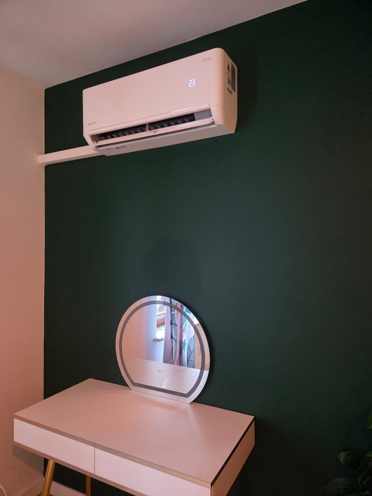 Klimatyzator Rotesno Teta 3.5 kW na zielonej ścianie salonu masażu, z widocznym wyświetlaczem temperatury i minimalistycznym designem.