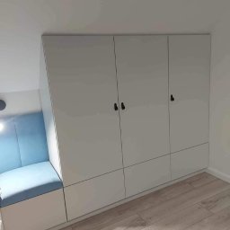 FjordWood - Meble na każdy wymiar - Biała szafa wnękowa z siedziskiem w kolorze błękitnym, czarne uchwyty, drewniana podłoga. Nowoczesny design, dopasowanie do skosu.