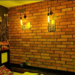 MG PROJEKT GRZEGORZ RADTKE - Pokój z ceglaną ścianą, dekoracjami 'New York' i fototapetą z panoramą miasta. Oświetlenie punktowe nadaje wnętrzu loftowy charakter.