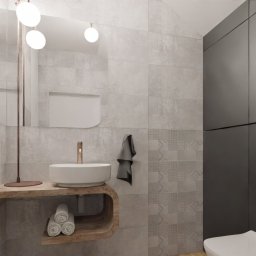 JAKUB SZELĄG PROJEKTOWANIE WNĘTRZ - Nowoczesna łazienka z umywalką na drewnianym blacie, szarą armaturą i wzorzystymi płytkami. Minimalistyczny design z akcentami miedzi i subtelnym oświetleniem.