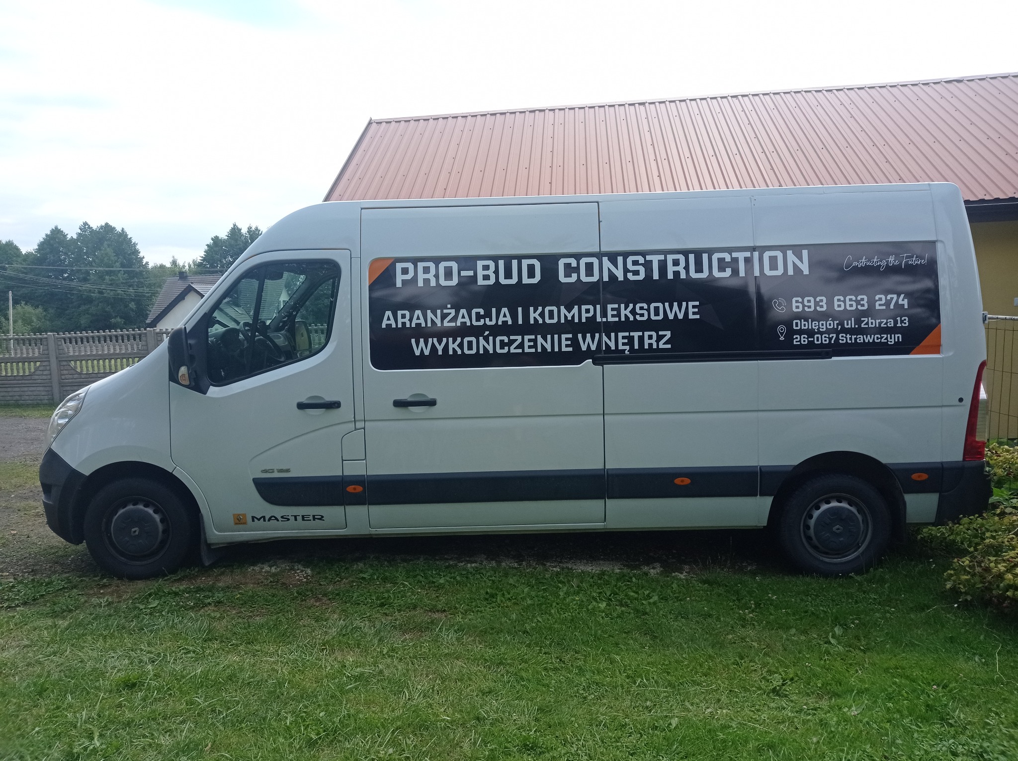 Biały van firmy PRO-BUD CONSTRUCTION z Strawczyna, oferującej aranżację i kompleksowe wykończenia wnętrz. Na boku pojazdu widoczne dane kontaktowe i logo firmy.