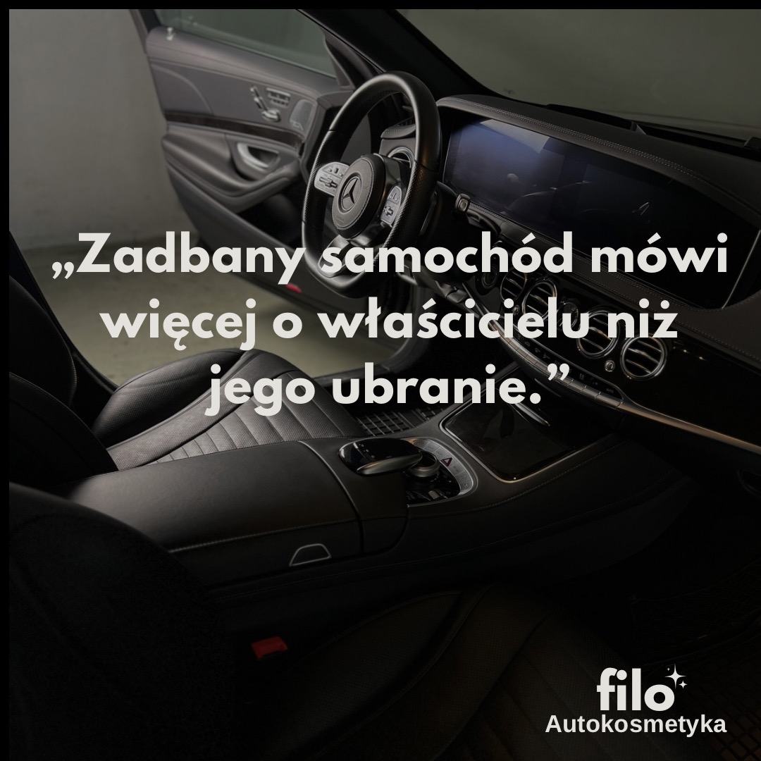Wnętrze luksusowego, czarnego samochodu Mercedes z deską rozdzielczą i fotelem kierowcy, z widocznym logo firmy autokosmetycznej w prawym dolnym rogu.
