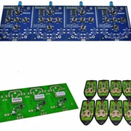 Różne modele płytek drukowanych, gotowych do montażu, prezentowane w Bolesławicach. Zielone i niebieskie PCB z elementami elektronicznymi.