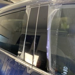 Perfect Clean Car detailing - Aplikacja bezbarwnej folii ochronnej PPF na elementy karoserii niebieskiej Mazdy. Widoczne mokre fragmenty folii i karoserii podczas montażu.