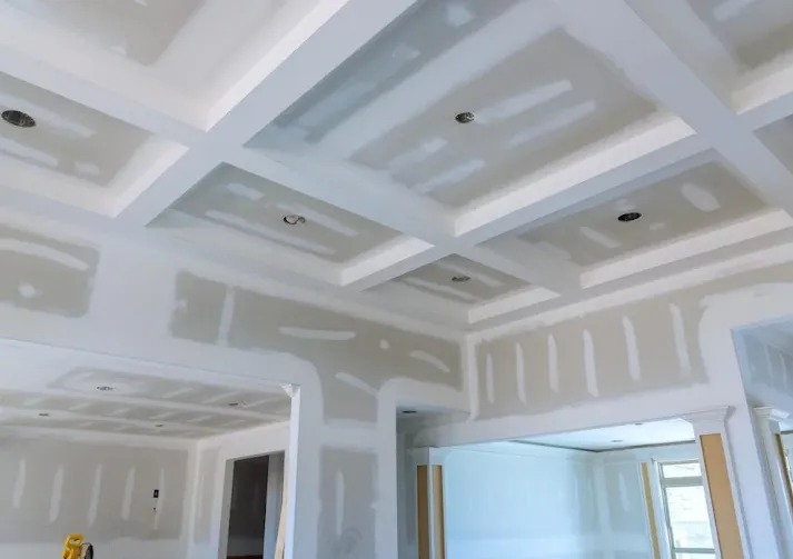 Wykończenie wnętrza: ściany i sufit pokryte gładzią gipsową, przygotowane do malowania, widoczne otwory na oświetlenie. Detal: dekoracyjny sufit kasetonowy.