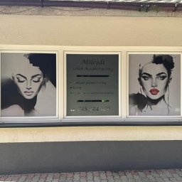 Marta Jankowska M.J StalTech - Oklejone okno salonu kosmetycznego z grafikami twarzy i danymi kontaktowymi. Czarno-białe portrety po bokach, nazwa salonu i oferta na środkowym panelu.