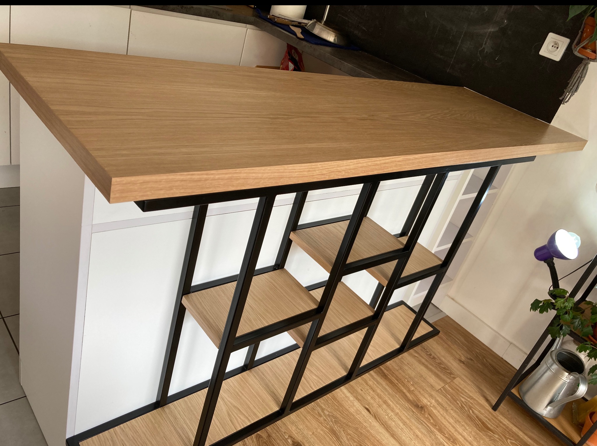 Loftowa konstrukcja: blat z drewna na metalowym stelażu z półkami. Geometryczny design, czarne ramy, jasne drewno. Nowoczesny minimalizm w detalu.