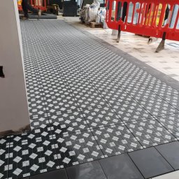 Glazkam - Ukończone układanie wzorzystej, czarno-białej podłogi z płytek w Lubsku. Widoczne detale wykończenia i wzór płytek. Praca glazurnicza.