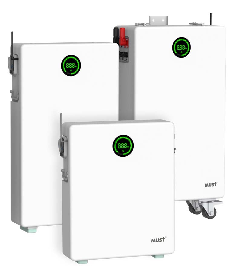 Trzy białe, prostopadłościenne jednostki magazynowania energii z zielonymi wyświetlaczami procentowymi, z logo MUST, na białym tle. Różne rozmiary, bliski kadr.