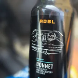 Butelka środka ADBL Bonnet do czyszczenia podsufitki i tapicerki samochodowej. Na etykiecie schemat wnętrza auta i kod QR do tutorialu.