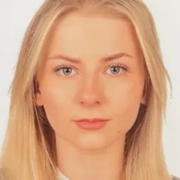 Portret młodej kobiety o jasnych włosach i zielonych oczach, na białym tle. Ujęcie centralne, z delikatnym oświetleniem.