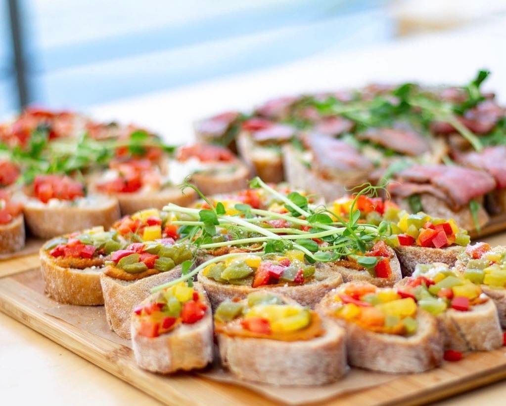 Apetyczne kanapeczki na desce: pieczywo z kolorowymi warzywami i świeżymi kiełkami, oraz z pieczonym mięsem. Idealne na imprezę, catering.