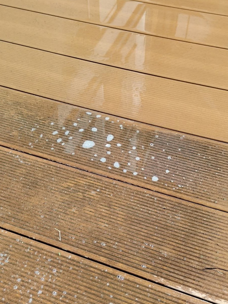 Czyszczenie desek tarasowych: Połowa tarasu umyta, druga pokryta pianą czyszczącą, ukazująca różnicę w wyglądzie przed i po zabiegu.