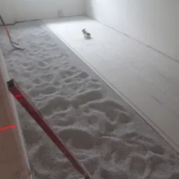 Wyrównywanie podłoża pod panele podłogowe za pomocą granulatu. Widoczny poziomica laserowa i płyty Fermacell. Przygotowanie do układania paneli w jasnym pomieszczeniu.