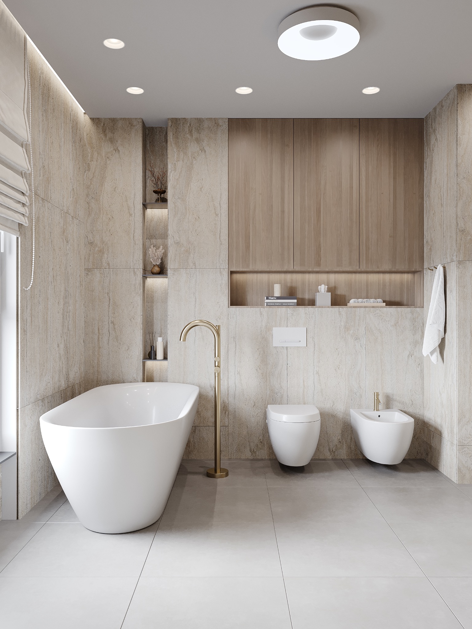 Nowoczesna łazienka z wanną wolnostojącą, toaletą, bidetem i złotą armaturą. Beżowe płytki imitujące kamień i drewniane szafki nadają wnętrzu elegancji.