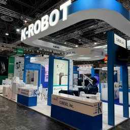 M&s bud construction spółka zoo - Stoisko targowe K-ROBOT Kiria Curexo, Inc. z robotami medycznymi, biało-niebieska kolorystyka, oświetlenie LED, elementy graficzne i ekspozycje. Prezentacja technologii medycznych.