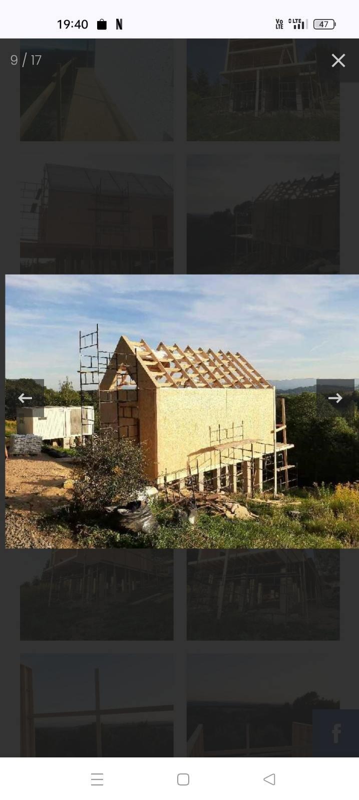 Budowa domu w stanie surowym otwartym: ściany z płyt OSB, więźba dachowa, rusztowania. Widok na wzgórza w tle.