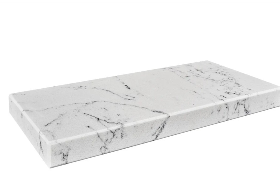 Biały, prostokątny blat z delikatnym, szarym wzorem żyłek, ukazany z bliska pod kątem, eksponujący gładką powierzchnię i zaokrągloną krawędź.