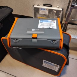 Łukasz Matuszewski usługi Elektryczne dla HoReCa i Domu - Miernik Sonel MPI-520 na torbie narzędziowej, obok drabina i walizka. Urządzenie do pomiarów elektrycznych, na obudowie naklejka o dofinansowaniu z Funduszy Europejskich.