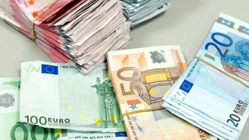 Stosy banknotów euro o różnych nominałach (100, 50, 20) leżące na blacie. Banknoty spięte gumkami recepturkami. Różne ujęcia nominałów.